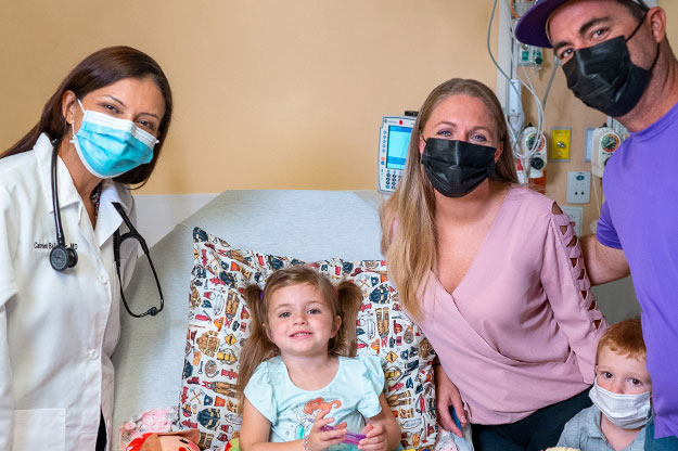 Kealy, who had neuroblastoma cancer, with her family and Carmen Ballestas, MD, hematologist/oncologist