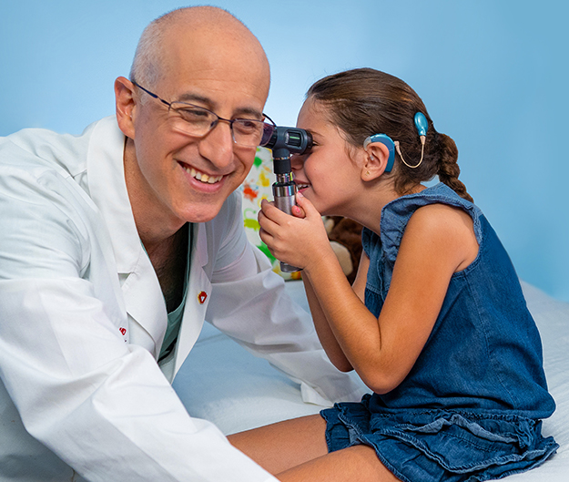 Nikki, who had a cochlear implant with her family and Samuel Ostrower, MD, Chief, Pediatric Otolaryngology, Head & Neck Surgery Program, Joe DiMaggio Children's Hospital