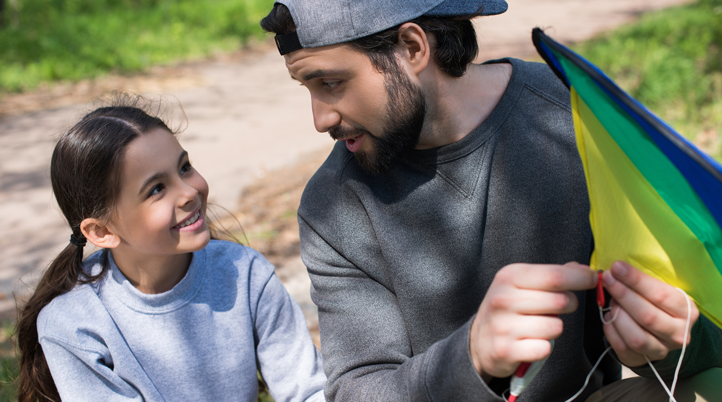 father talking to daughter in park blog