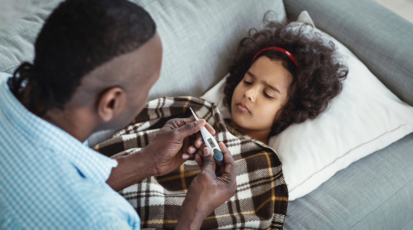 dad taking temperature of sick daughter