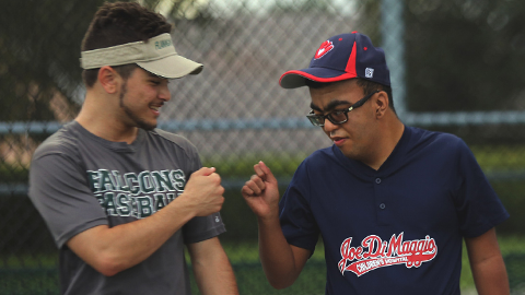 fist bumping baseball participants at miracle league