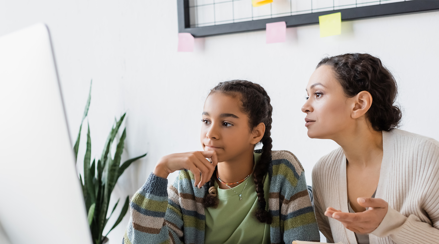 mother and teen daughter looking at computer
