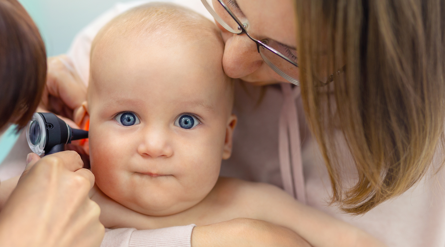 pediatrician examining infants ear