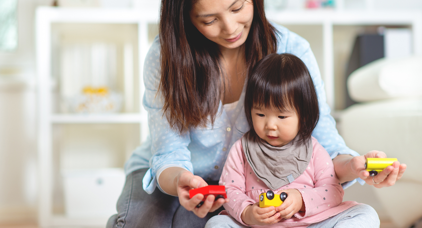 mom playing with toddler with toys