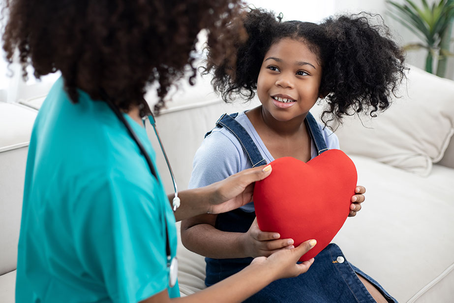 Child holding heart, talking to daughter