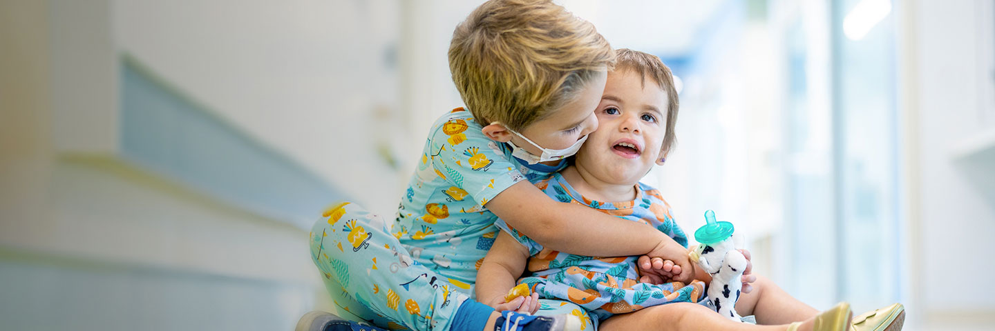 Young patient hugged by sibling at Joe DiMaggio Children’s Hospital