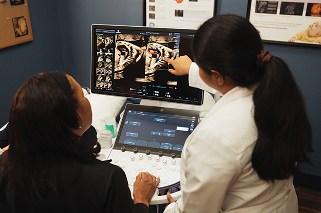 Fetal heart nurses viewing fetal echo on monitor