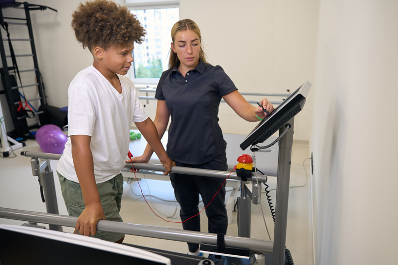 Kid in threadmill with therapist