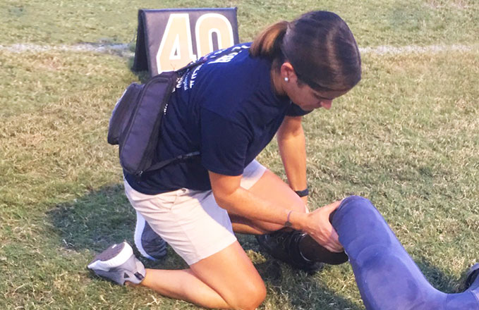 Athletic trainer performing a sideline assessment 