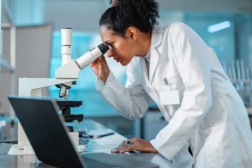 Researcher using microscope