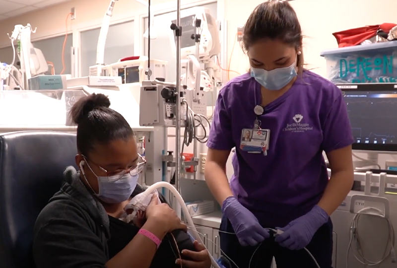 nurse helping mom kangaroo care NICU newborn