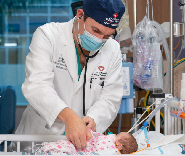 Brian Boe, MD, Medical Director, Pediatric Cardiac Interventional Services, and Amelia, who was born with patent ductus arterosis (PDA), with her parents.